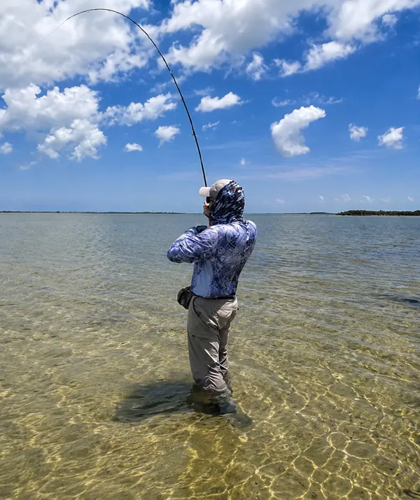 Angler wading the Cozumel flats hooked up on a bonefish.